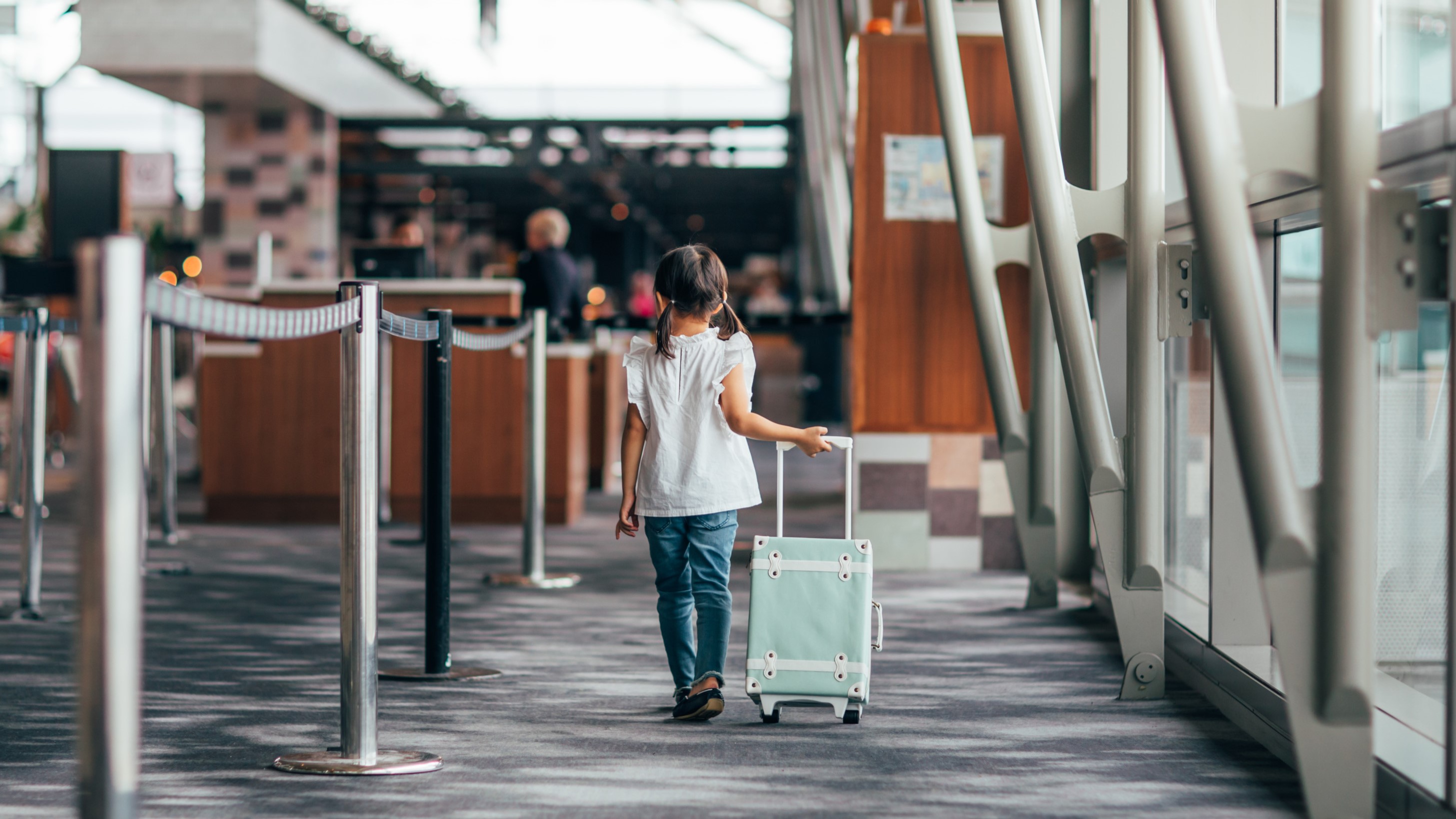 Child pulling a blue suitcase at the International Terminal