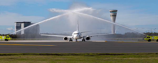 First plane on the new runway in Brisbane with water cannon from fire trucks